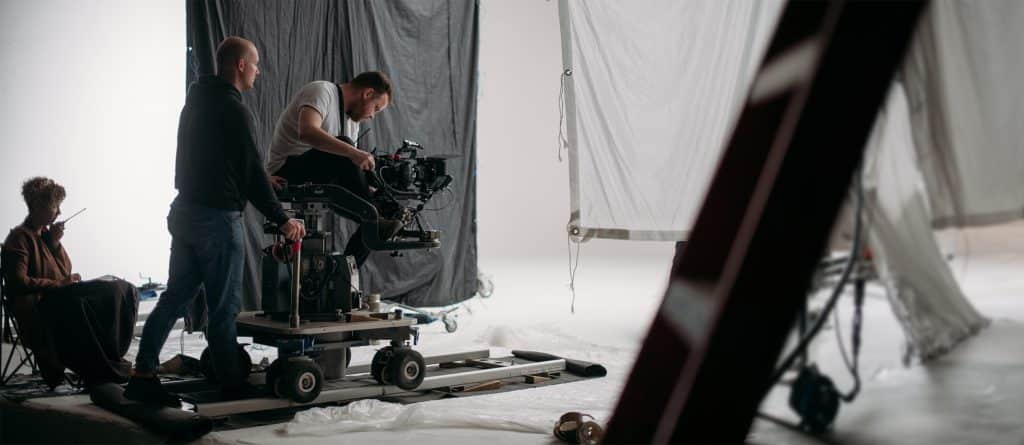 Professional videographer on the set of a film, commercial, or TV series. Filming indoors, studio