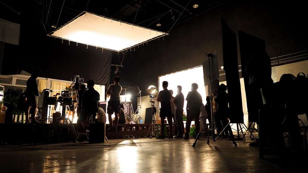 on-set at a video production, which includes: video production crew, lighting and talent